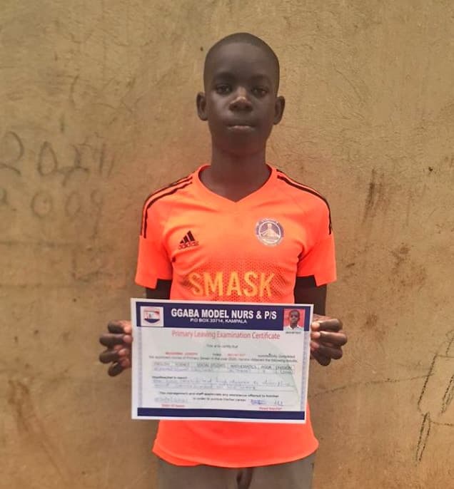 Joseph, in his orange jersey, holds up his Ggaba Model Nursery and Primary School leaving certificate.