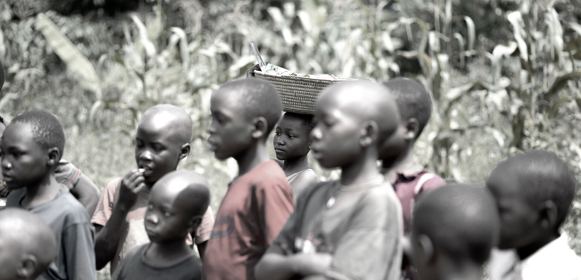 Black-and-white photo of a group of children standing together outdoors.
