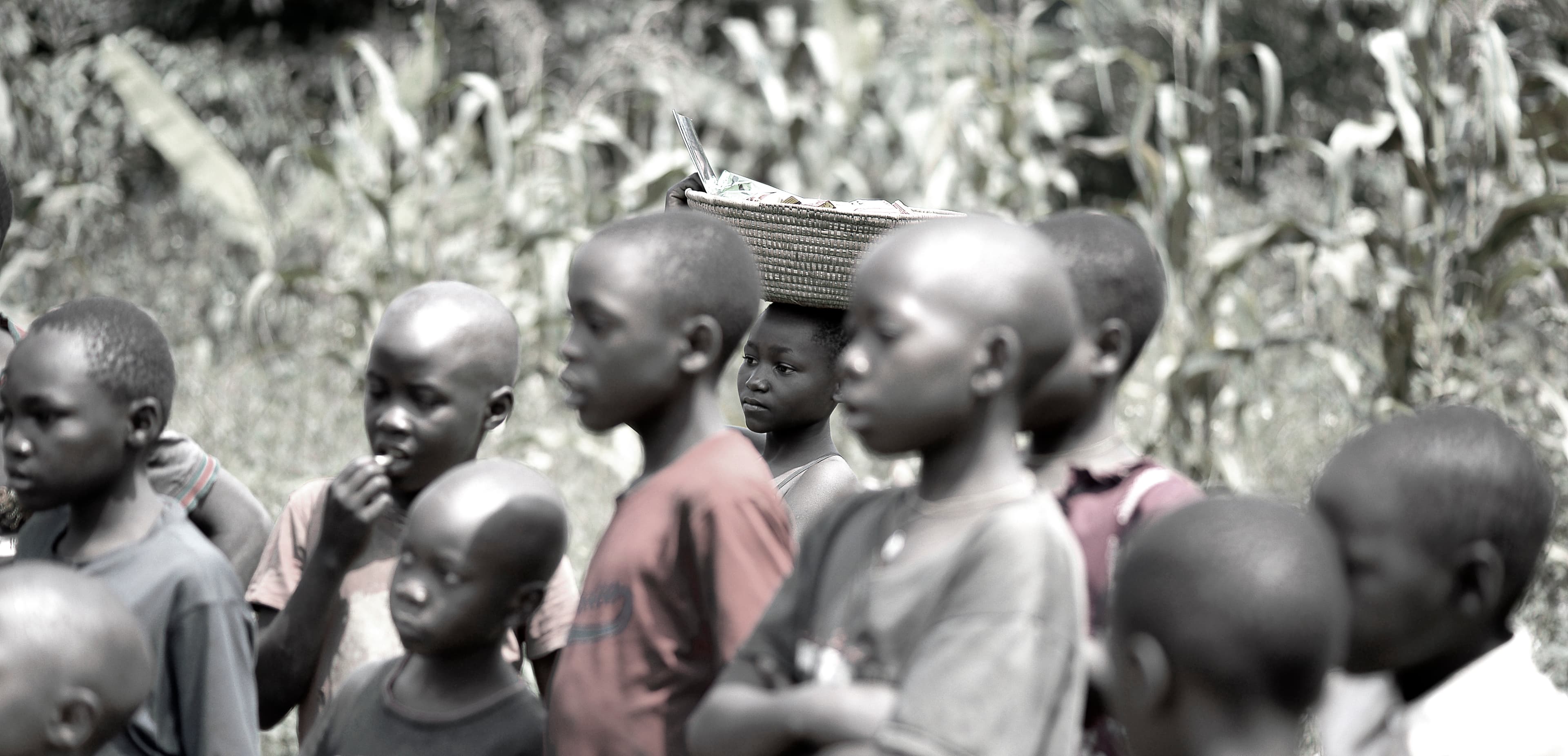 Black-and-white photo of a group of children standing together outdoors.