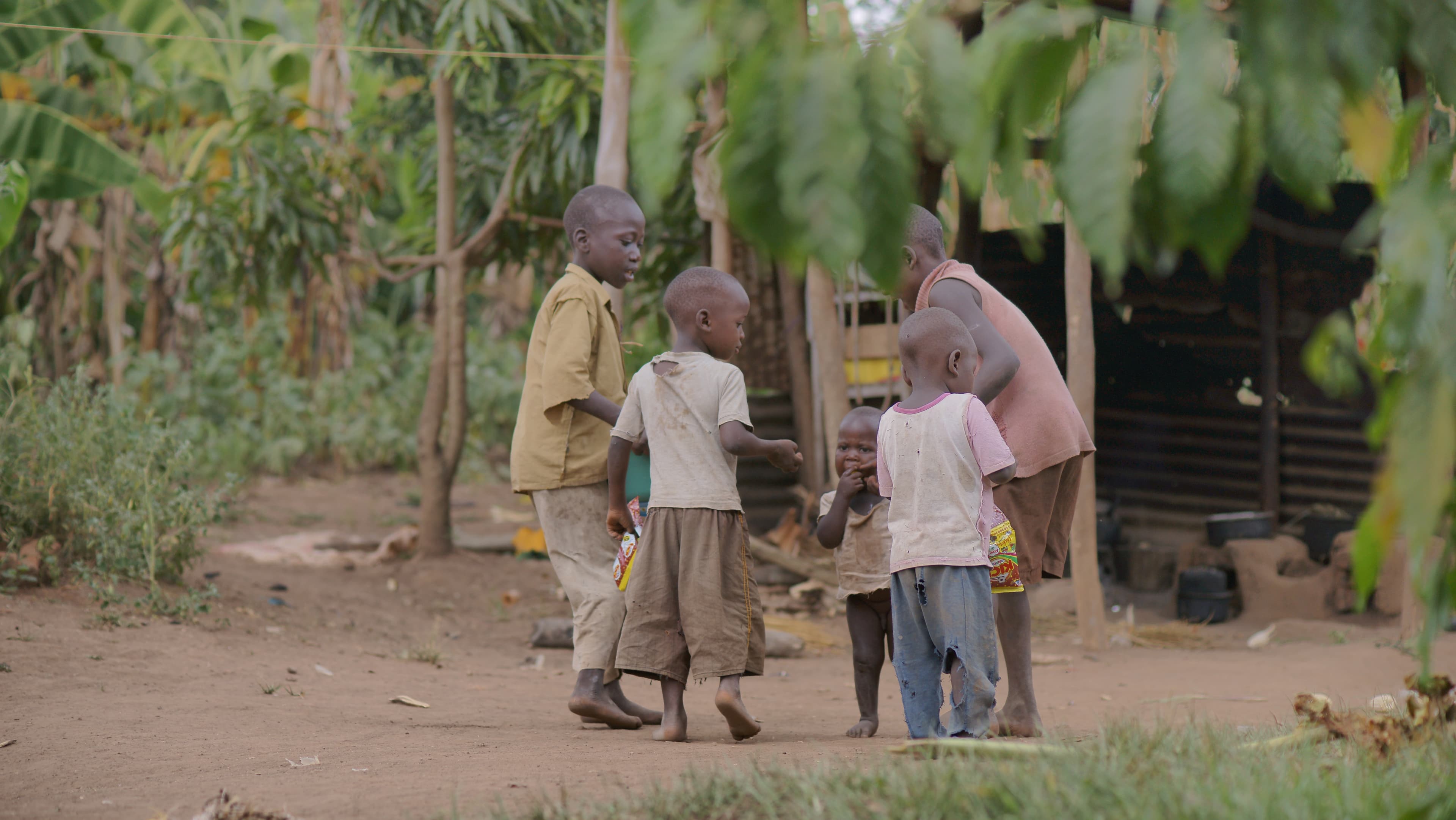 Group of children standing together outdoors near a wall