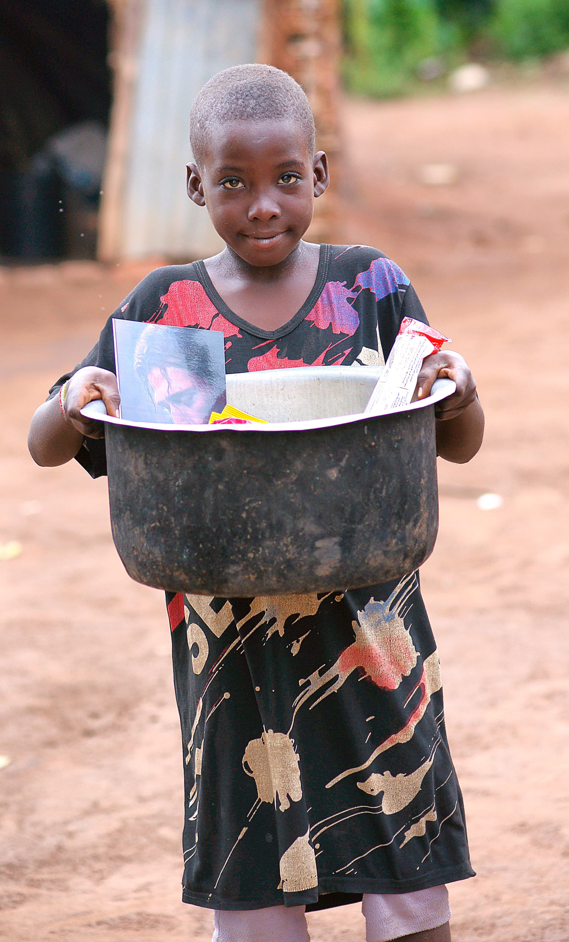 Young girl holds a metal pot topped with a photo card.