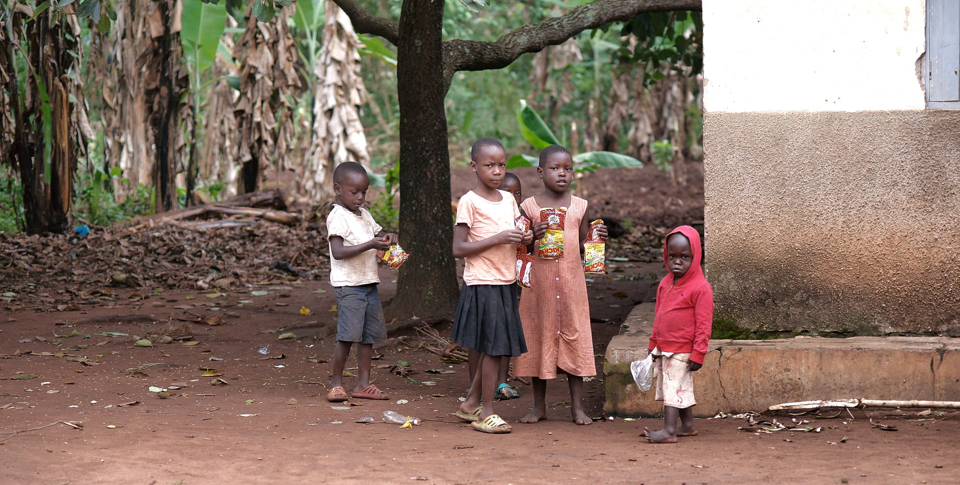 Group of children stand together outside near a building.