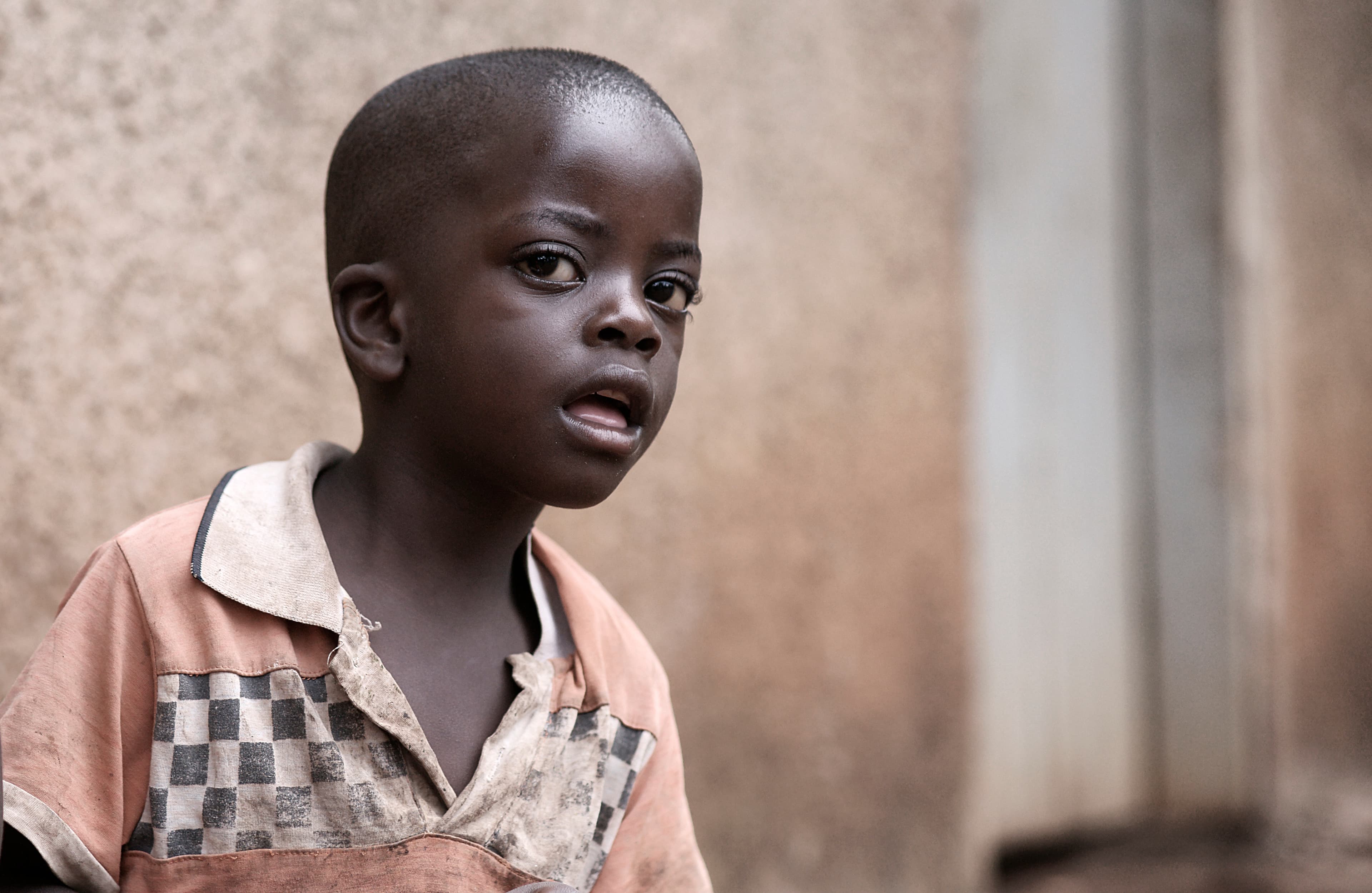 Black-and-white close-up portrait of a young boy in a checked shirt.