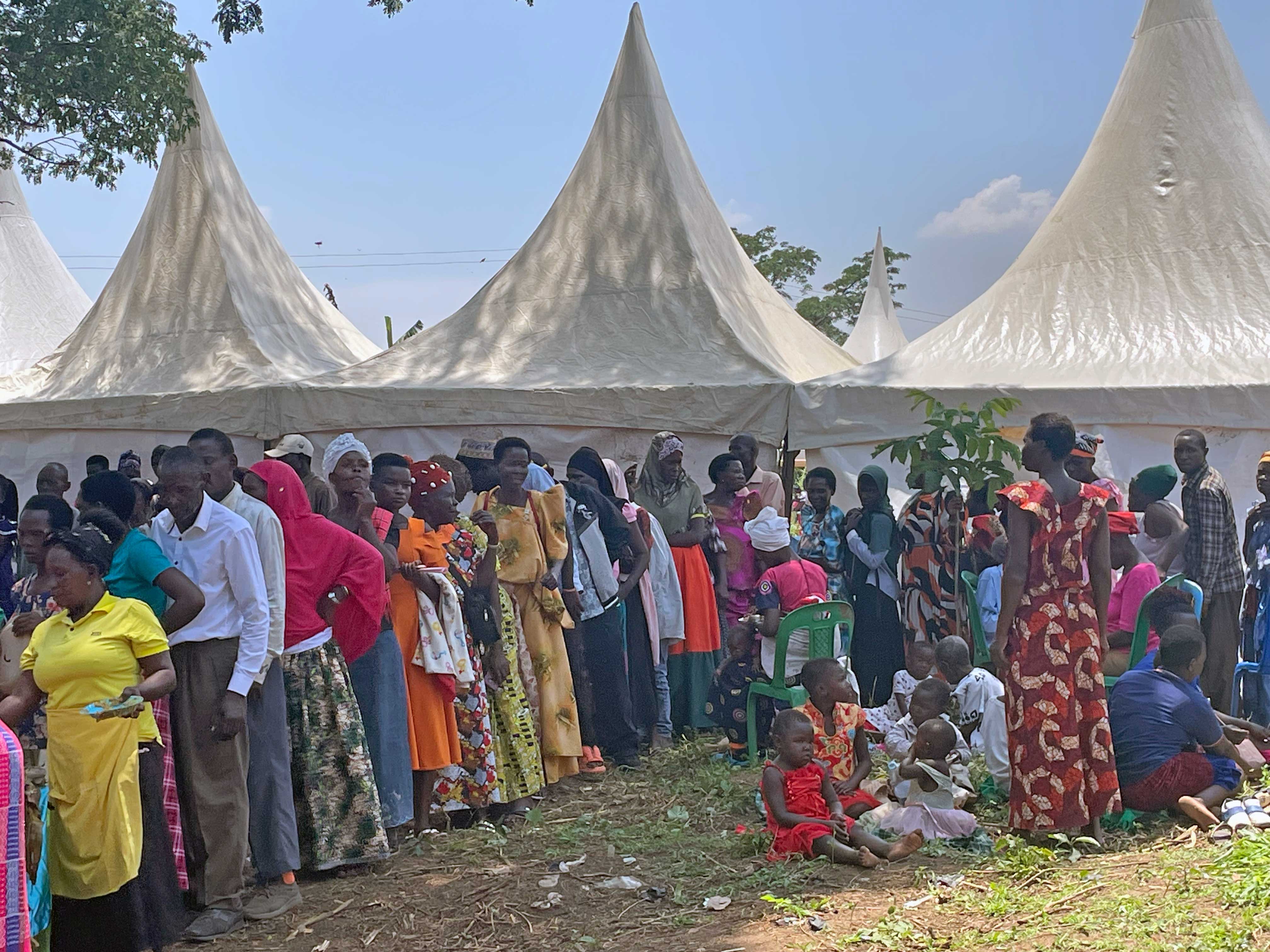 A large crowd gathers outside under white event tents at the Miracle Medical Centre opening.