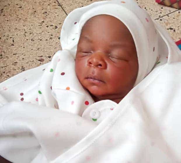 A sleeping newborn baby wrapped in a white blanket and cap at Miracle Medical Center.