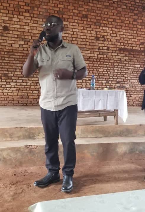 A man talks on a phone outside a church building.