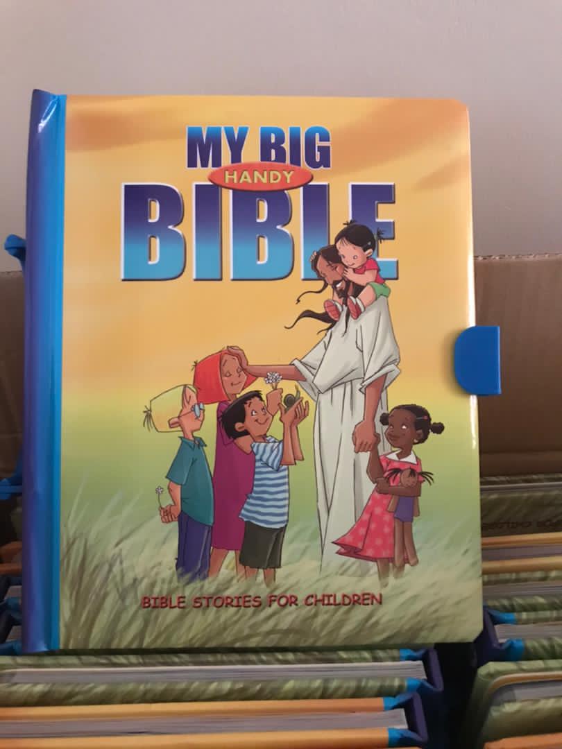 Cover of a children's 'My Big Bible' storybook stacked with others on a shelf.