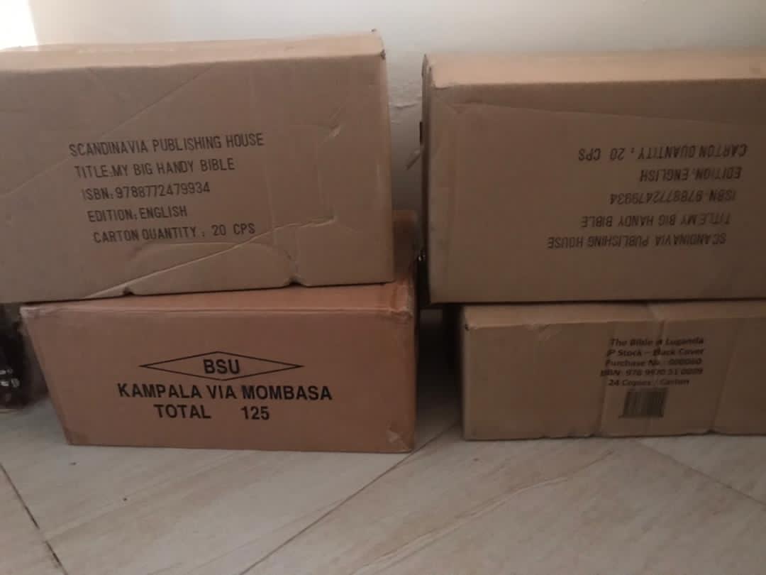 Stacked cardboard shipping boxes of Bibles labeled for delivery via Mombasa.
