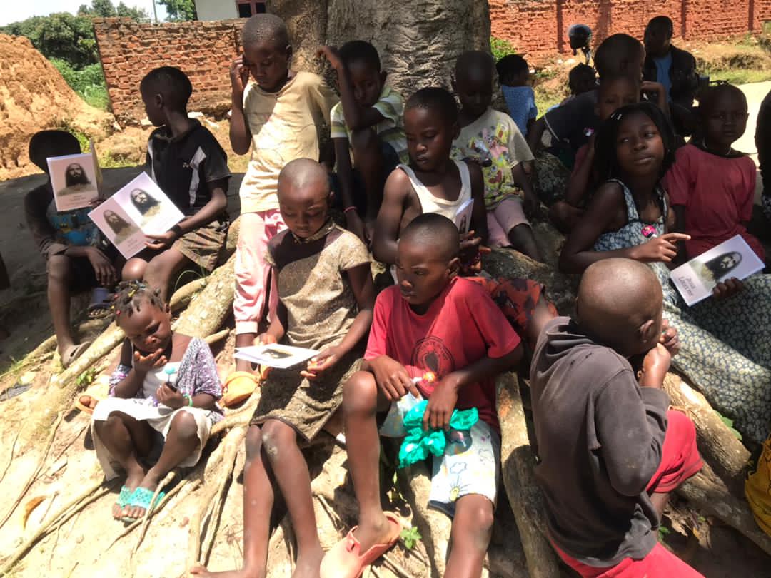 Group of children seated together holding gospel tract booklets and candy