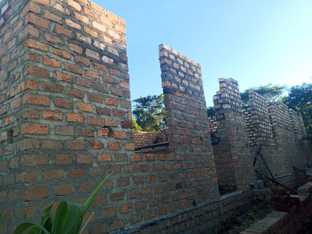 Partially built brick school structure with unfinished walls and no roof, at Amazing Grace Church.