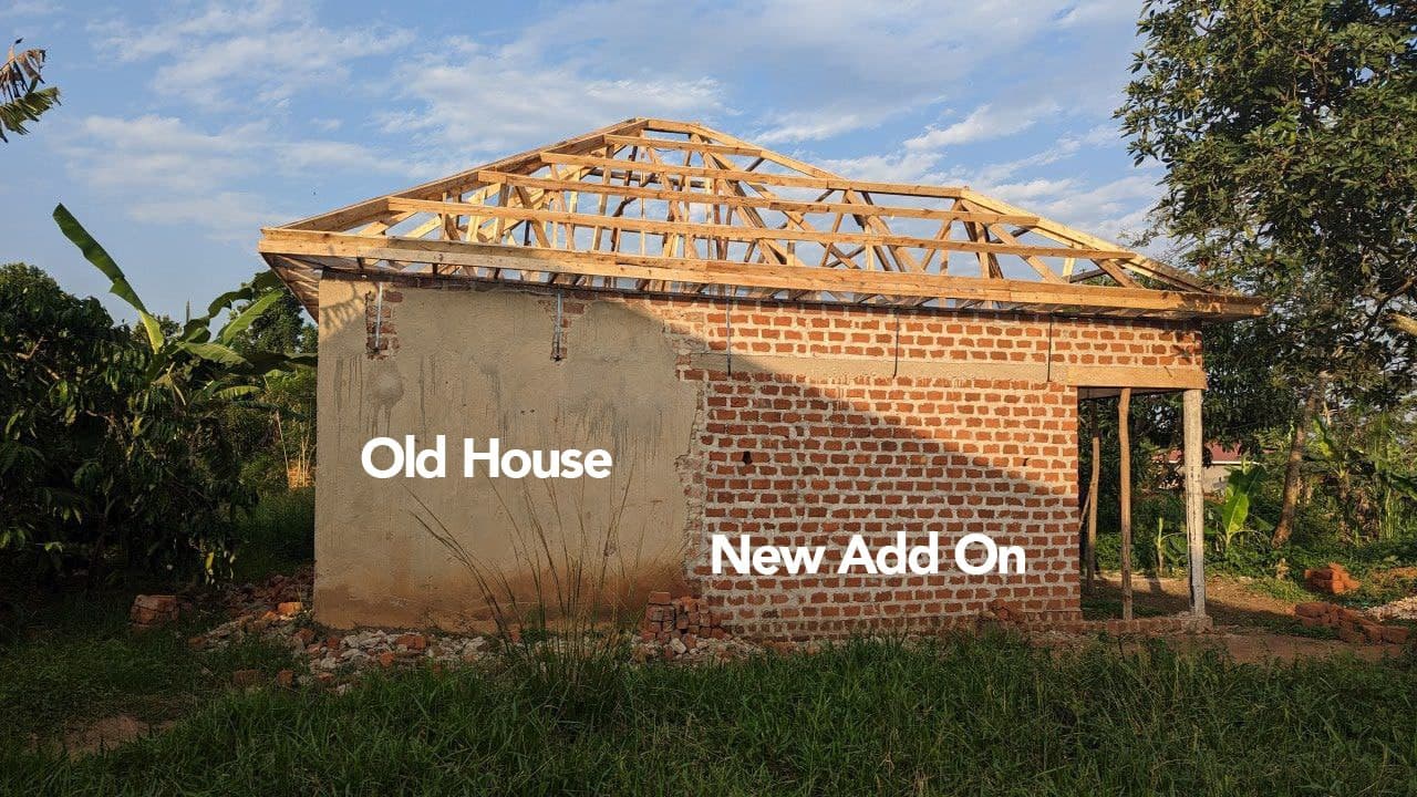 A partly built brick house with roof framing, labeled photo overlay reading Old House and New Add On.