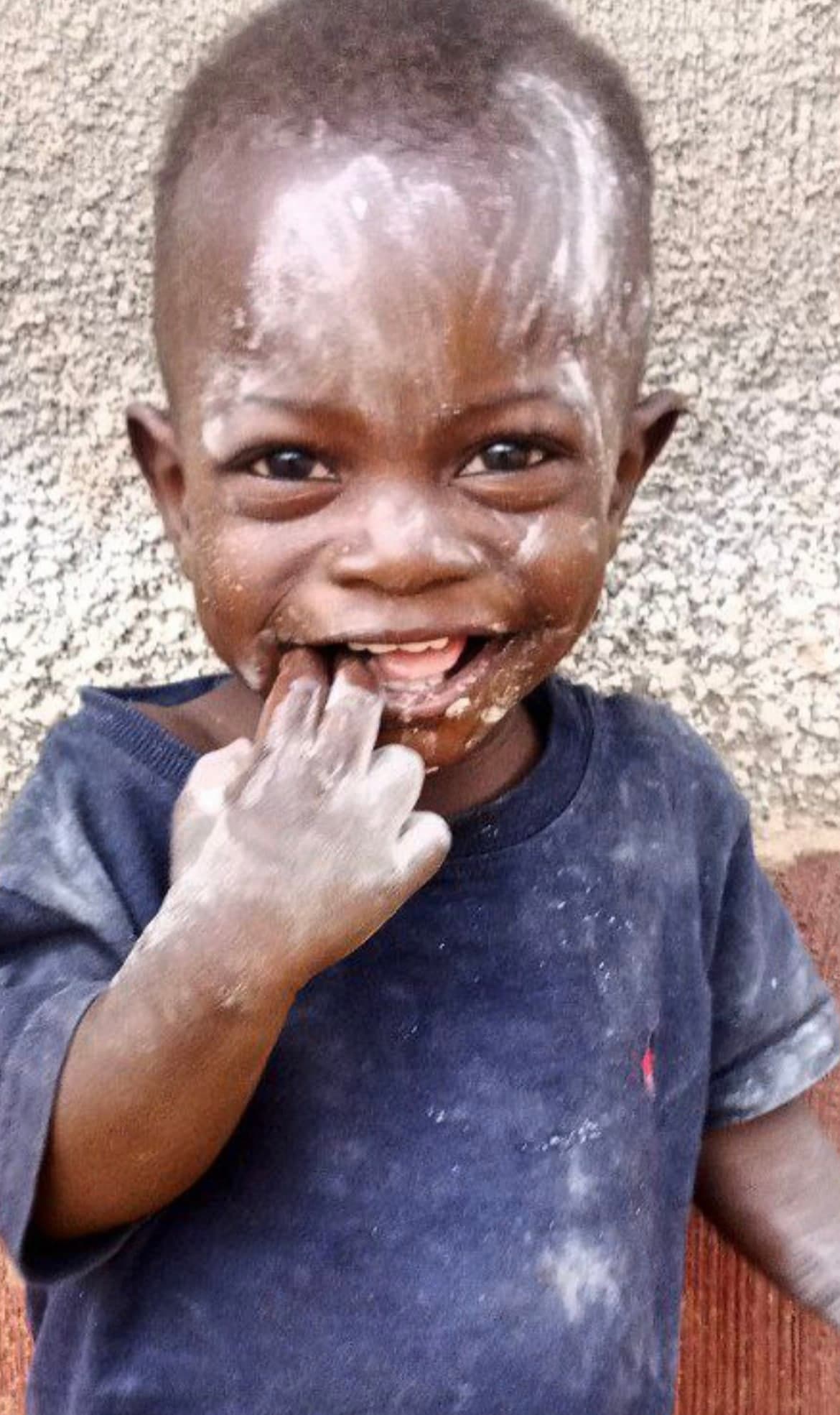 Close-up of a smiling young child's dirt-smudged face at Mashariki Children's Home.