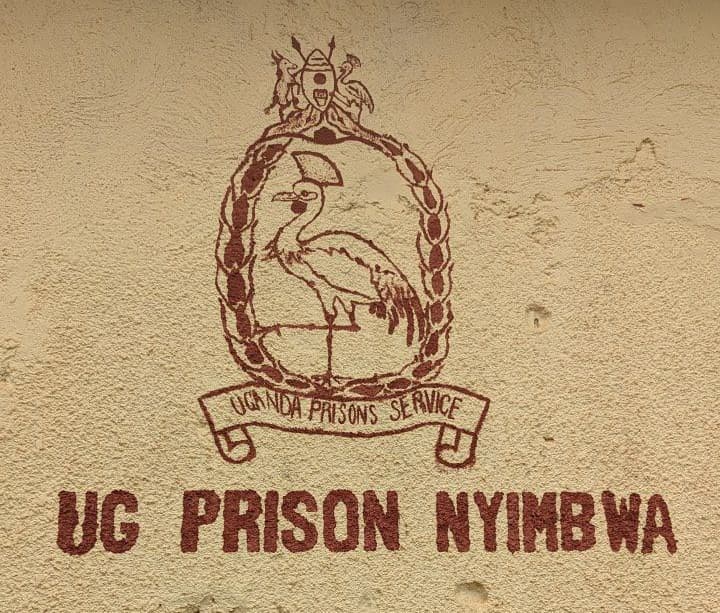 Uganda Prisons Service emblem painted on a wall reading "UG PRISON NYIMBWA."