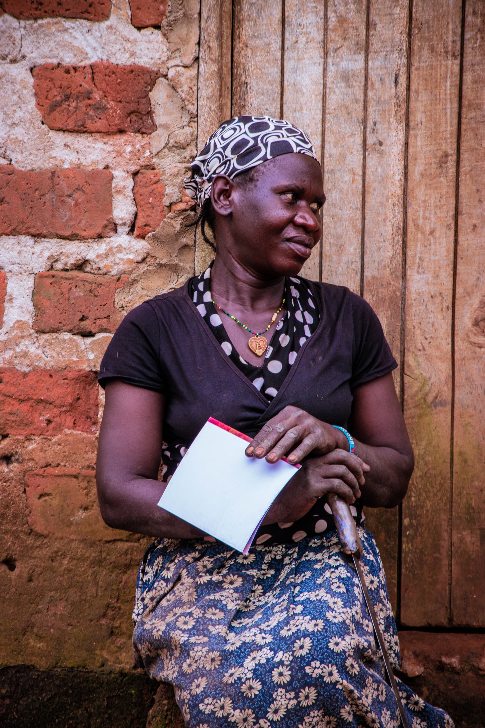 A woman in a headscarf, likely Irene, seated outdoors holding a gospel tract.
