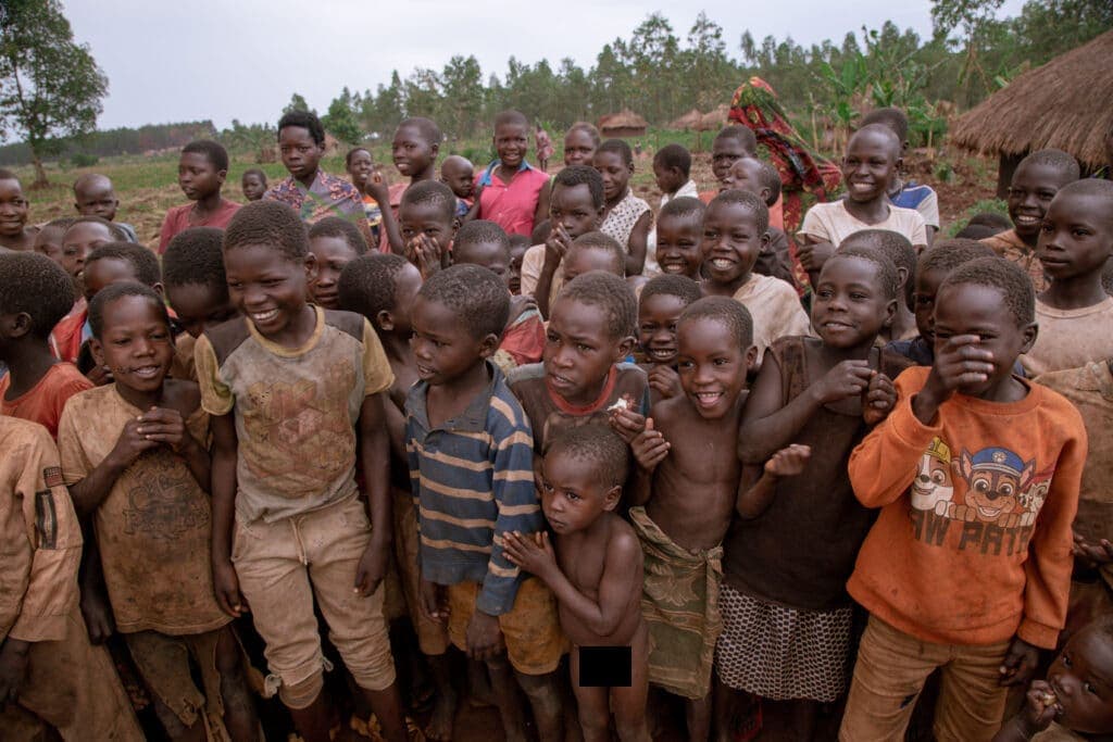 Large crowd of smiling village children gathered together outdoors for a JFM food and gospel outreach.