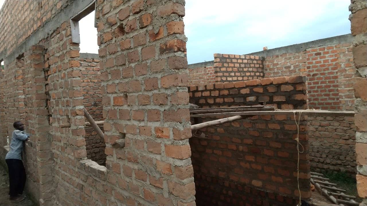 Exterior view of an unfinished brick building at the Corinth Vocational Training Institute construction site.