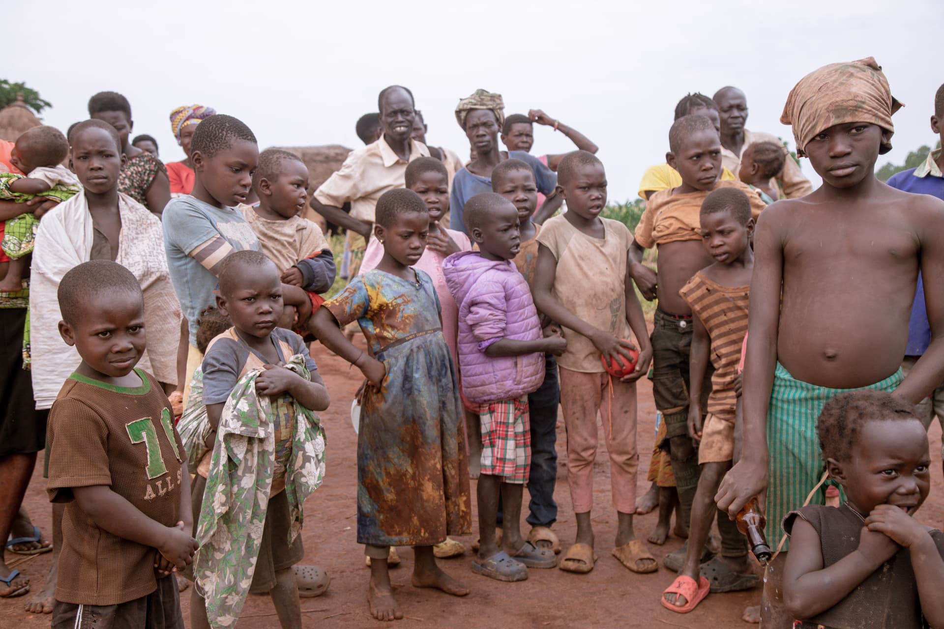 A large crowd of children and adults gathers outdoors during JFM's outreach trip in Northern Uganda.